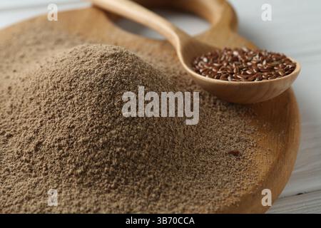 Leinsamenmehl und Löffel mit Samen auf dem Tisch, Nahaufnahme Stockfoto