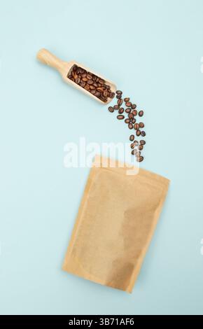 Foto von Bohnen, die in einen blauen Papierbeutel gegossen werden und für Branding- oder Werbematerialien bestimmt sind Stockfoto