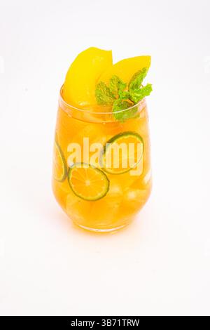 Gelbes Pfirsich- und orangenes Zitrusgetränk mit frischen Minzblättern und Eis serviert in klarem Glas auf weißem Hintergrund. Hochwertige Fotos Stockfoto