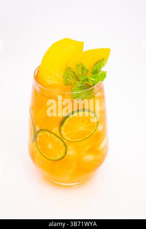 Gelbes Pfirsich- und orangenes Zitrusgetränk mit frischen Minzblättern und Eis serviert in klarem Glas auf weißem Hintergrund. Hochwertige Fotos Stockfoto