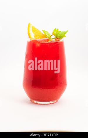 Vibrierender Cocktail aus roten Beeren mit Orangenscheibe und frischen Minzblättern, serviert in klarem Glas mit Eis auf weißem Hintergrund. Hochwertige Fotos Stockfoto