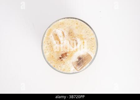 Eiskaffee mit Sahne und Eiswürfeln serviert in hohem, klarem Glas mit schaumiger Oberseite, fotografiert auf weißem Hintergrund. Hochwertige Fotos Stockfoto
