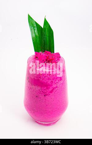 Leuchtender rosafarbener Smoothie in transparentem Glas mit grünem tropischem Blattgarnitur auf weißem Hintergrund mit Drachenfrucht. Hochwertige Fotos Stockfoto