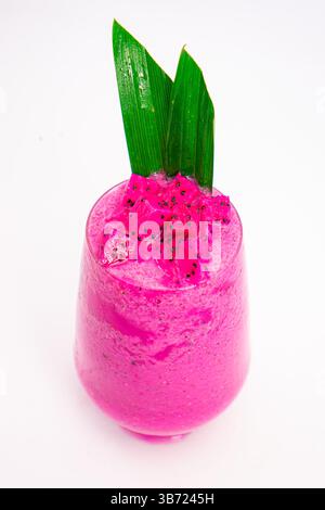 Leuchtender rosafarbener Smoothie in transparentem Glas mit grünem tropischem Blattgarnitur auf weißem Hintergrund mit Drachenfrucht. Hochwertige Fotos Stockfoto