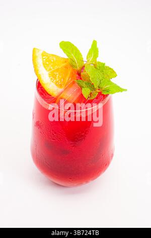 Vibrierender Cocktail aus roten Beeren mit Orangenscheibe und frischen Minzblättern, serviert in klarem Glas mit Eis auf weißem Hintergrund. Hochwertige Fotos Stockfoto