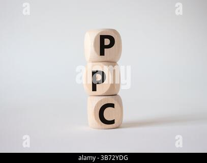 PPC – Symbol „Pay per Click“ (Zahlung per Klick). Holzwürfel mit den Worten PPC. Schöner weißer Hintergrund. Business- und PPC-Konzept. Kopierbereich. Stockfoto