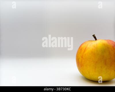 Frischer saftiger gelber Apfel mit Stab oben auf weißem Hintergrund rechts von der Vorderansicht des Bildes Stockfoto