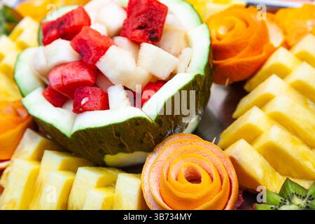 Dekorativer Obstsalat auf fruchtigem Hintergrund. In Scheiben geschnittene Wassermelone, Melone, Ananas und Grapefruit. Stockfoto