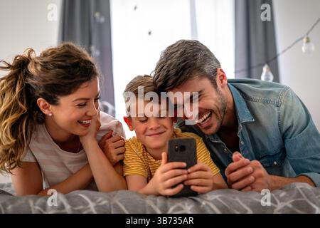 Familie ab drei Personen verbringt fröhlich gemeinsam zu Hause. Eltern, Kinderglückskonzept Stockfoto