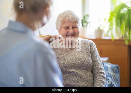 Weibliche häusliche Betreuerin, die eine ältere Frau emotional unterstützt Stockfoto
