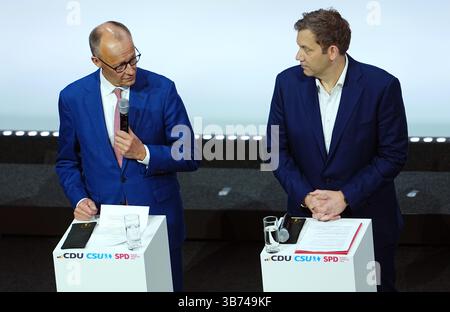 Berlin, Deutschland. Mai 2025. CDU-Vorsitzender und Kandidat für Bundeskanzler Friedrich Merz (l) und SPD-Vorsitzender Lars Klingbeil, designierter Bundesfinanzminister und Vizekanzler, stehen vor der Unterzeichnung des Koalitionsabkommens zwischen CDU, CSU und SPD auf der Bühne. Quelle: Kay Nietfeld/dpa/Alamy Live News Stockfoto