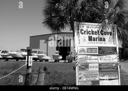 Boote legten an einem klaren Küstentag an der Cricket Cove Marina in Little River, South Carolina, USA, an. Stockfoto