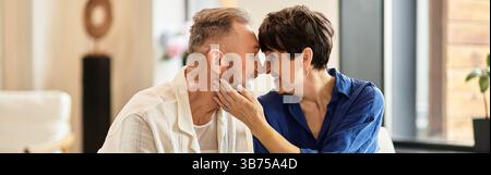 Ein Paar mittleren Alters genießt einen liebevollen Moment zu Hause, um sich im Glück zu erfreuen, Banner Stockfoto