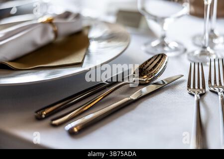 Besteck versilbertes Besteckset mit komplizierten Designs, elegant auf einem festlichen Tisch platziert, was das kulinarische Erlebnis noch angenehmer macht. Stockfoto