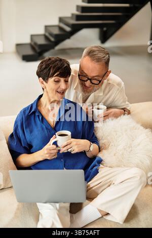 Ehemann und Ehefrau mittleren Alters teilen Momente der Freude, während sie zu Hause Zeit miteinander verbringen. Stockfoto