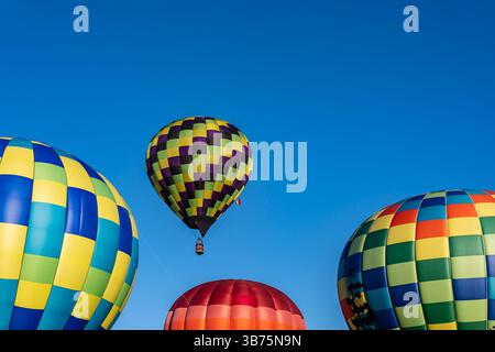 Leuchtende Luftballons aller Formen und Farben schweben in den klaren blauen Himmel und erfüllen die Luft bei einem klaren Ballonfest im Herbst mit Spannung. Die sc Stockfoto