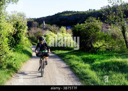 Touristen auf einer Radtour, Radtour von Ljubljana nach Piran in Slowenien, Radfahren auf einer Schotterstraße in der Nähe des Dorfes Cernotice in der Region Karst Stockfoto