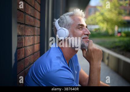 Medizinisches Personal, das sich mit Musik außerhalb des Krankenhauses entspannt. Stockfoto