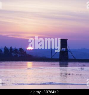 Jäger-Turm neben dem Teich im Winter bei Sonnenaufgang Stockfoto