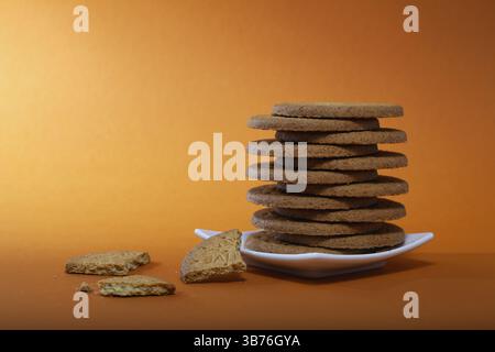 Stapel von leckeren Schokoladenkeksen auf braunem Hintergrund Stockfoto