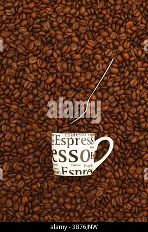 Eine Tasse Kaffee auf einem Tisch voller Kaffeebohnen. Kaffeedesign Stockfoto