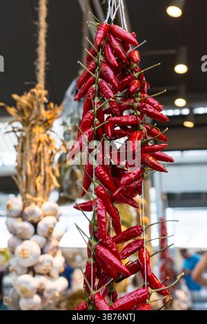 Bündel scharfer getrockneter Paprika, die auf einem Bauernmarkt in Portugal hängen Stockfoto