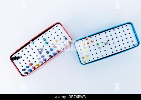 Das Bild verfügt über zwei verschiedene Aufbewahrungskästen in Rot und Blau, die jeweils mit verschiedenen leuchtenden Markierungen mit feiner Spitze gefüllt sind, die ein organisiertes Arrangement darstellen Stockfoto