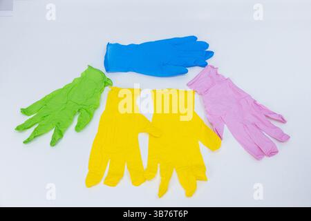 Dieses Bild zeigt eine Sammlung von bunten Gummihandschuhen, einschließlich grün, rosa, gelb und blau. Ideal für verschiedene Aufgaben wie Reinigung und Schutz Stockfoto