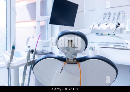 Moderne Zahnarztpraxis mit hochwertigem Zahnarztstuhl und Ausstattung für effektive Mundheilverfahren und Patientenkomfort in einem sanften Licht Stockfoto