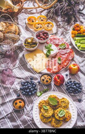 Picknick, Vorspeisen und Käse- und Fleischplatte mit süßen und herzhaften Muffins und Obst Stockfoto
