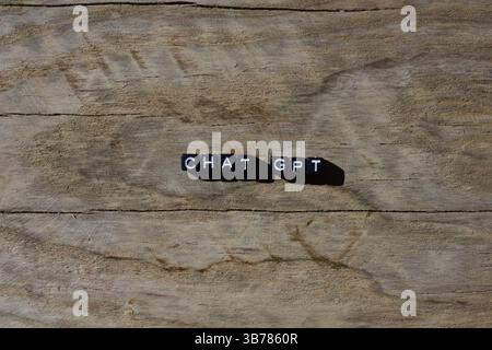 Chat gpt aus schwarzen Kunststoffperlen auf gerissenem Holzhintergrund. Begriff der Wörter Chat gpt mit Kopierraum. Stockfoto