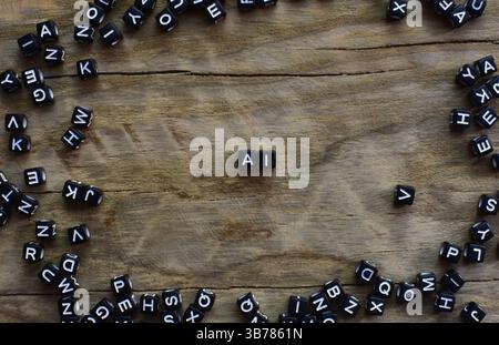 Symbole AI aus schwarzen Kunststoffperlen auf gerissenem Holzhintergrund, eingerahmt in verschiedene Buchstaben. Konzept der Buchstaben AI mit Kopierraum. Stockfoto
