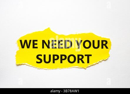 Wir brauchen Ihr Unterstützungssymbol. Gelbes Papier mit Worten. Wir brauchen Ihre Unterstützung. Schöner weißer Hintergrund. Business und wir brauchen Ihr Supportkonzept. Stockfoto