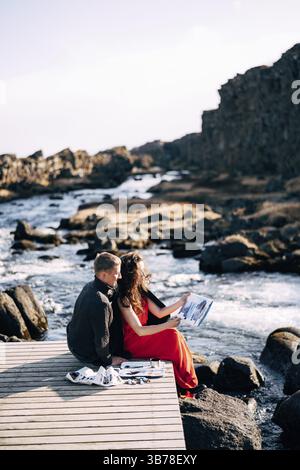 Der Typ umarmt die Künstlerin, die das Bild in den Aquarellfarben des Albums malt. In der Nähe des Ehsaraurfoss Wasserfalls, des Ehsarau River, Tingwedlir Nation Stockfoto