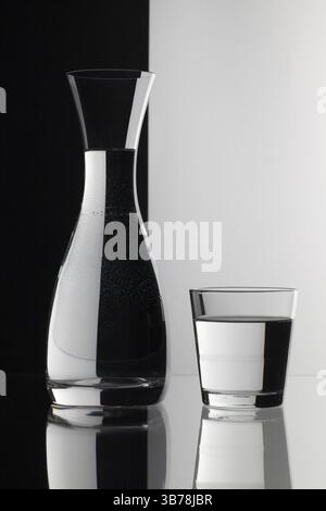 Gläser Wasser auf den schwarzen und weißen Hintergrund auf dem Glastisch Stockfoto