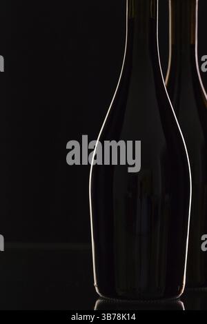 Zwei verschiedene Flaschen Wein auf dem schwarzen Glas Stockfoto