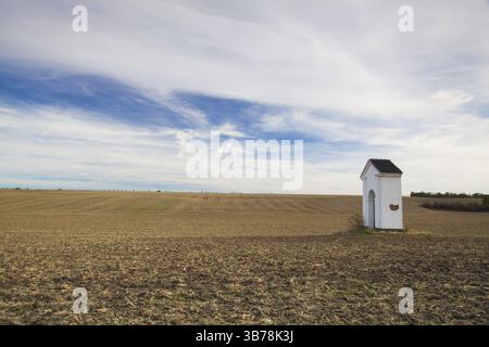 Kleine Kapelle im Herbst. Herbst Landschaft mit landwirtschaftlichen Nutzflächen, vor kurzem gepflügt und für die Ernte vorbereitet. Mittelböhmische Hochebene, Tschechische Re Stockfoto