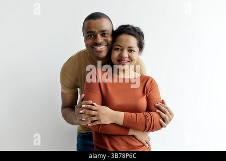 Romantisches Paar. Glücklicher Junger Schwarzer Mann Und Frau, Die Sich Auf Weißem Hintergrund Umarmen Stockfoto