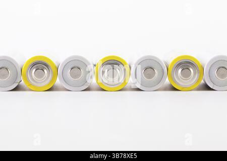 Energetischer abstrakter Hintergrund weißer und gelber Batterien. Alkali-Mangan-Batterie AA Stockfoto