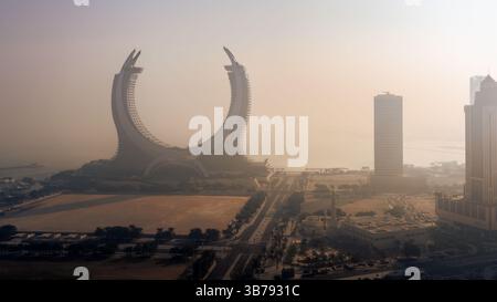 Doha, Katar [24. Februar 2025]: Ein nebeliger Morgen in Doha mit Wolkenkratzern, die teilweise im Nebel verborgen sind und eine geheimnisvolle und ruhige Stadtlandschaft schaffen. Stockfoto