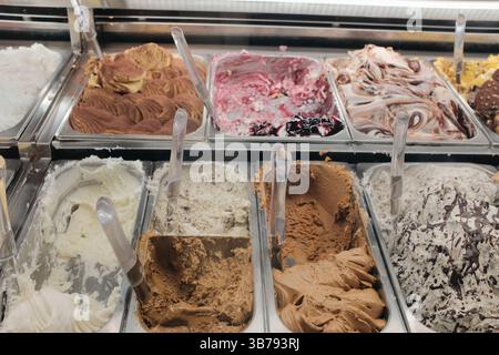 Italienisches Eis aus nächster Nähe und Einkaufsszene auf dem Nachtmarkt in Rom mit dekorativen Lichtern und festlicher Menge. Hochwertige Fotos Stockfoto