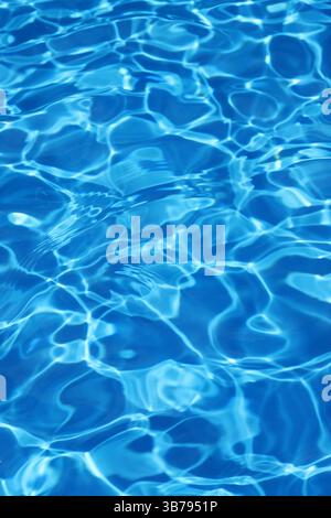 Leichte Wellen reflektieren im blauen Wasserhintergrund des Schwimmbades Stockfoto