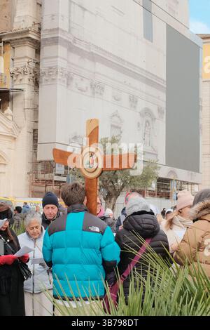 Religiöse Prozession in Rom mit einer Gruppe von Pilgern, die während des Jubiläums der Pilger der Hoffnung Rom 2025 ein großes Holzkreuz durch die historische Straße tragen Stockfoto