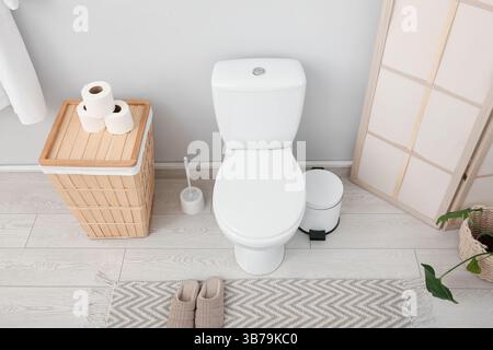 Das Innere des stilvollen Toiletten mit Keramikschale, Mülleimer und Korb Stockfoto