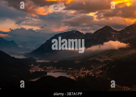 Wunderschöner Blick über die Alpen und die Schweizer Alpen und die Stadt in den Sonnenuntergang- und Sturmwolken über St. Moritz, Maloja, Graubünden, Schweiz. Stockfoto