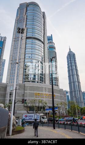 Shanghai, China - 1. April 2025: Blick auf den China Development Bank Tower in Pudong mit Menschen, moderner Architektur und abendlichem Verkehr auf der Straße Stockfoto