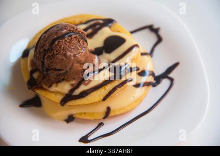 Pfannkuchen mit Schokoladeneis und Sahnesauce Stockfoto