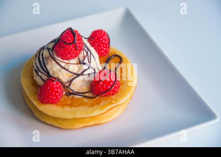 Pfannkuchen mit Eis, frischen Himbeeren und Schokoladensauce Stockfoto