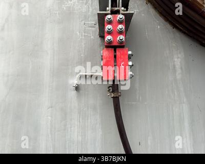 Industrielle Drahtseilklemme an Betonwand, Kabelverankerungssystem Stockfoto