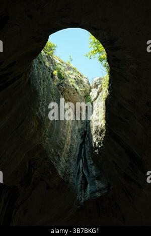 Blick vom Inneren der Prohodna-Höhle mit Blick auf das natürliche Skylight, Bulgarien Stockfoto